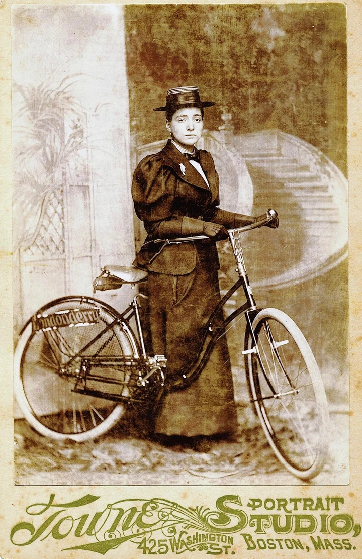 Studio portrait of Annie Londonderry standing with her bicycle, circa 1896.
